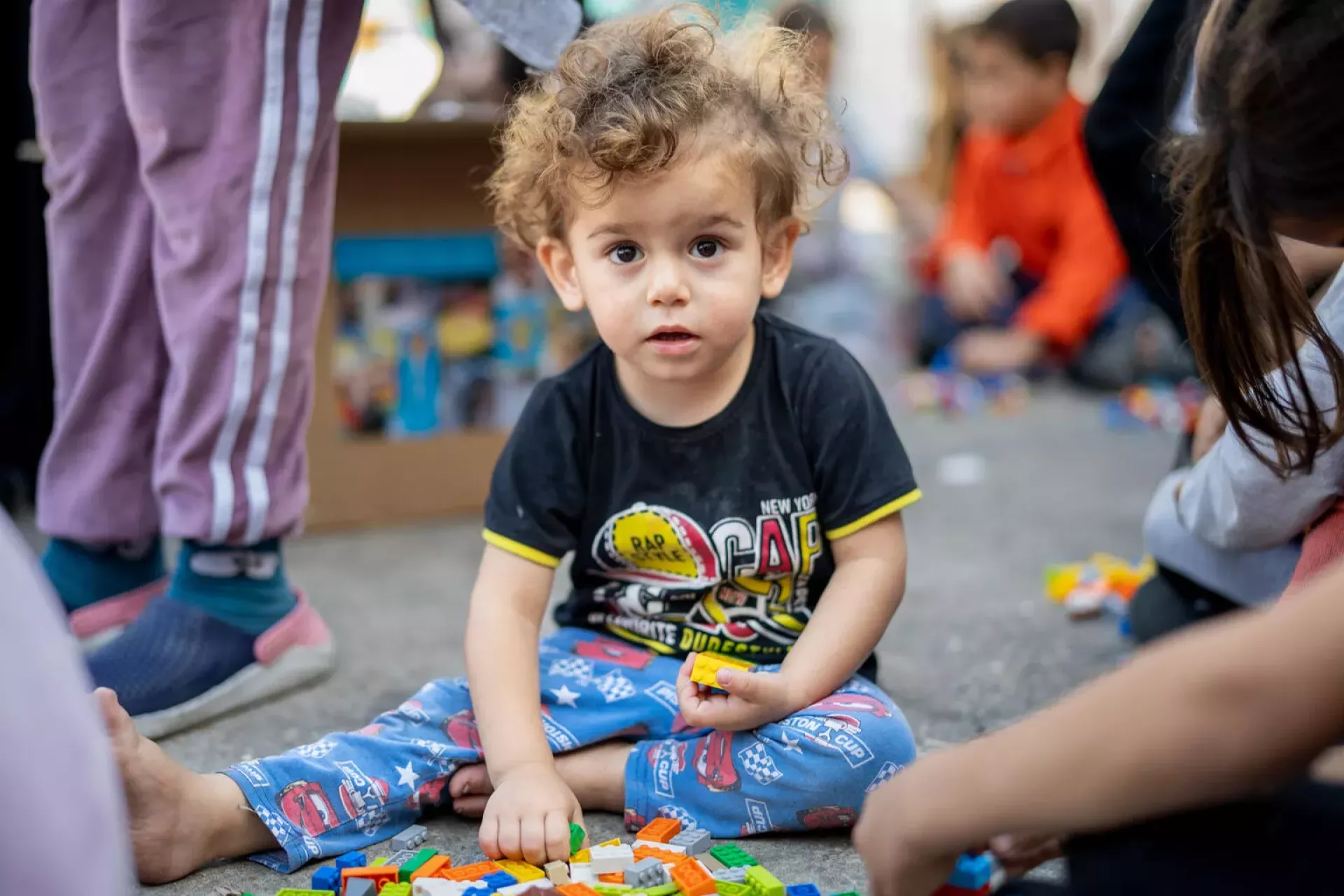 Lebanon. A child sits on the ground playing a game.