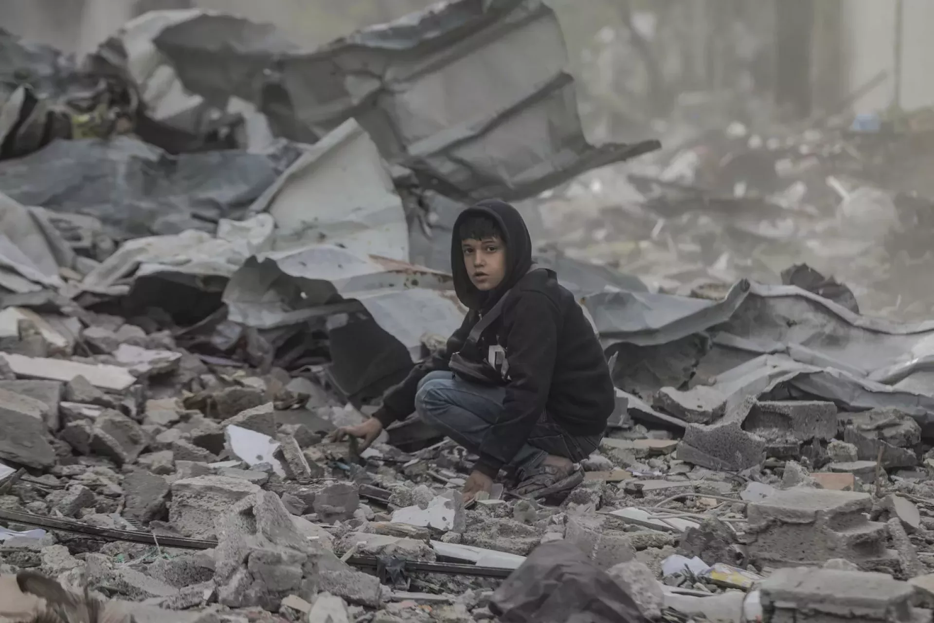 Gaza Strip. A boy crouches amid rubble in northern Gaza.
