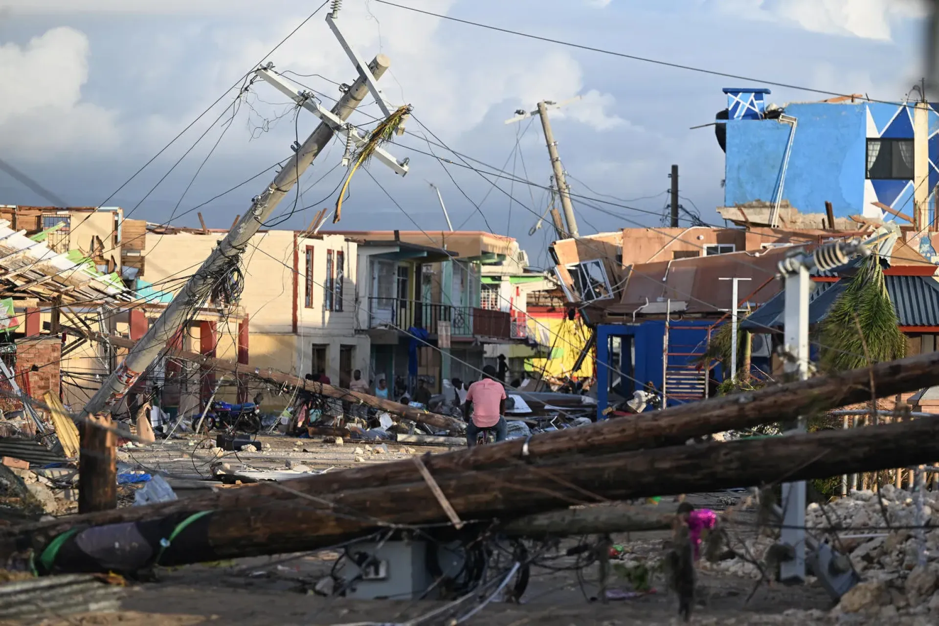 Jamaica. Electrical poles are down as a man bikes through the destroyed neighborood of North Street following the passage of Hurricane Melissa, in Black River, Jamaica.