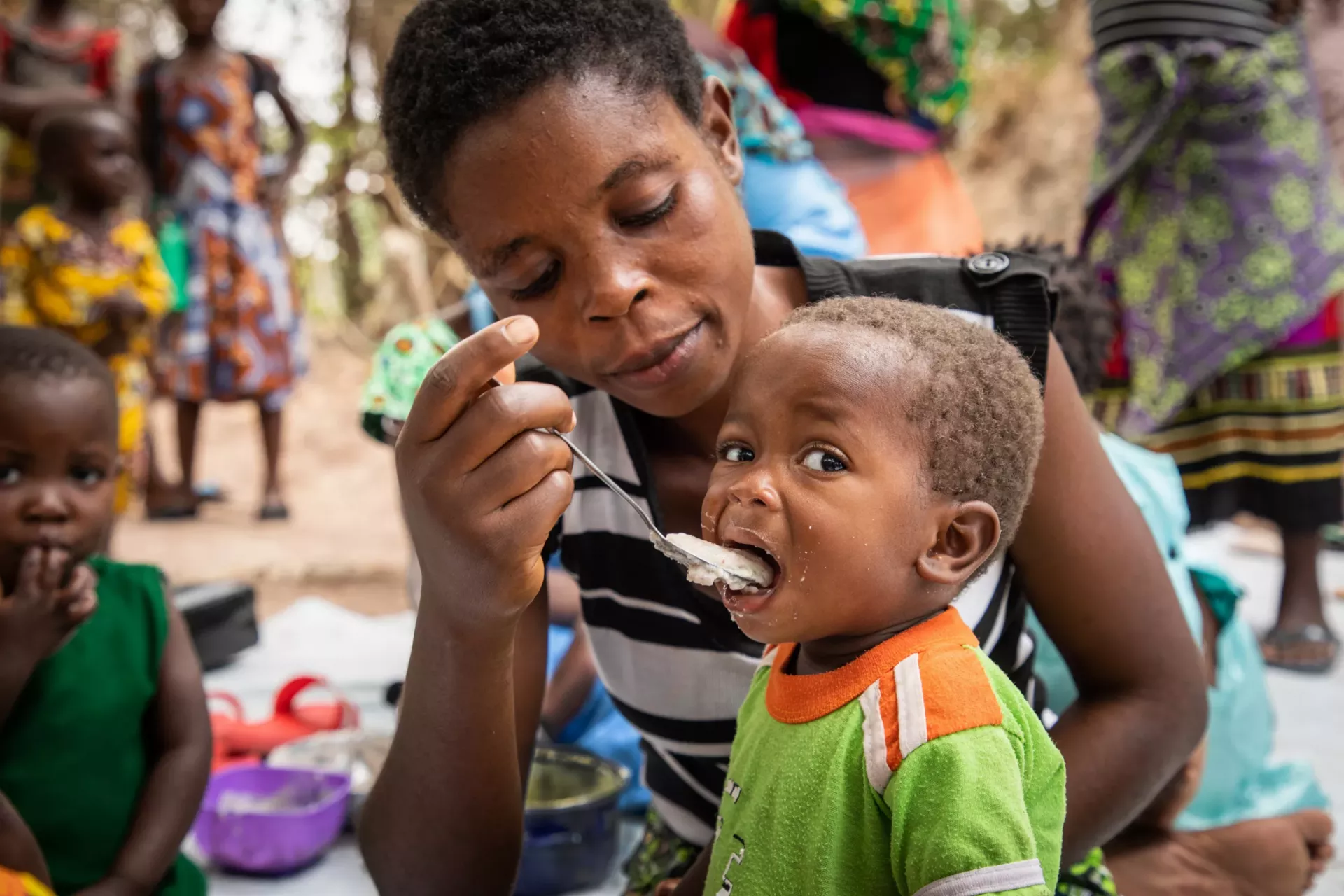 photo of child being fed by woman