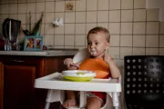 Matviy enjoys yoghurt for breakfast in his highchair.