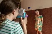 Mykyta&rsquo;s aunt, 13-year-old Daryna, pretends to take a picture of him with a toy camera.
