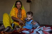 Pakistan. A woman sits with her young grandchild on the floor of a health centre.