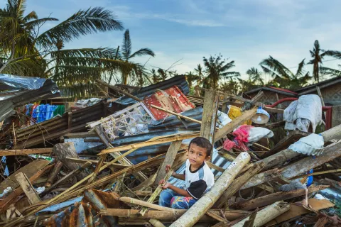 A child amidst rubble after a hurricane