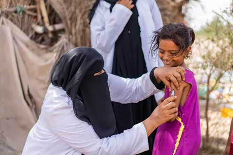 in Aden Governorate, Yemen, health worker Ghada Ali Obaid vaccinates 9-year-old Aswar Saddiq Othman