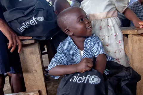 Haiti. A child puts his hand into a bag containing UNICEF-supplied school supplies.