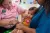 A child in her mothers arms receives a vaccine jab