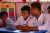 Bangladesh. Three boys look at a report card in a class room in a camp in Cox's Bazar.