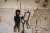 Syria. A wall painting of a child painting is picture on a damaged wall of a classroom.