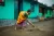 A woman in the village cleans the front of her house. 