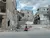 Syria. A woman and a child walk past destroyed buildings.