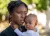 Haiti. A woman holds her child in the courtyard of a temporary shelter.