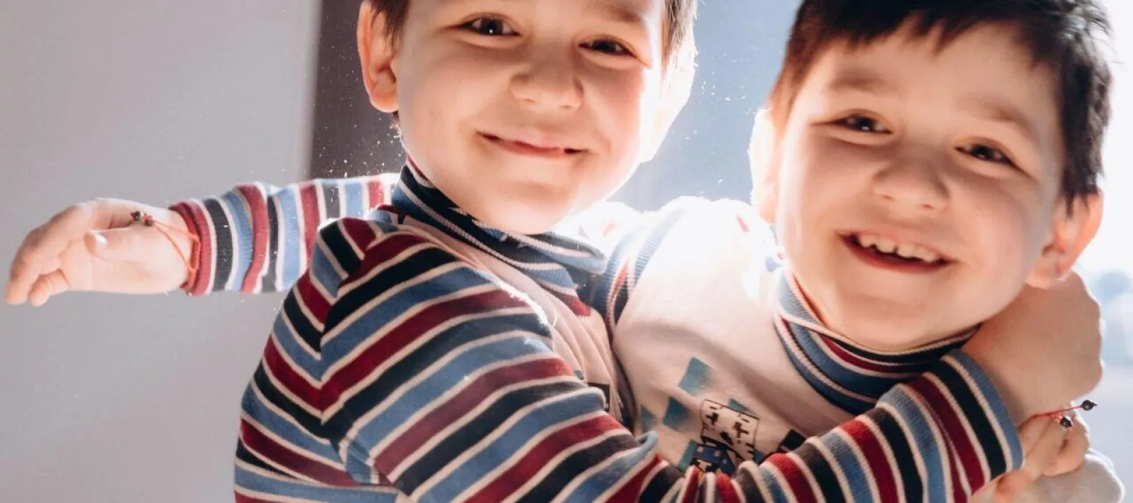 Twin boys from Ukraine hug each other and play.