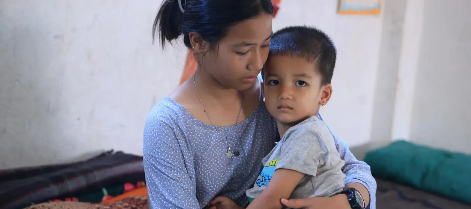 A 13 year old girl holds her younger brother after escaping a flashflood in Nepal.