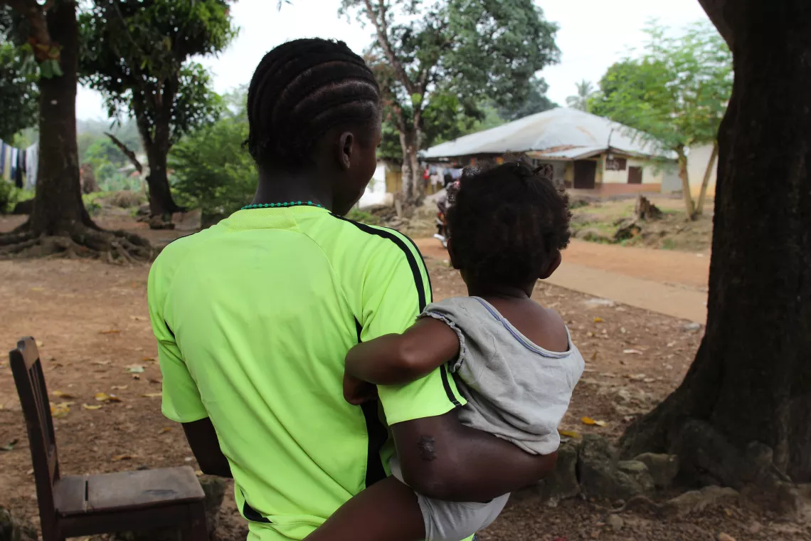 Fanta holds her young child.