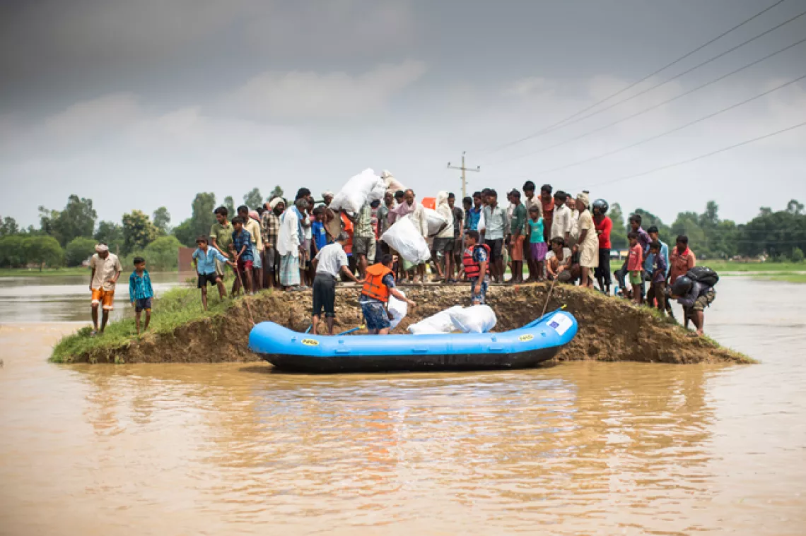 Nepalese police reach a flood affected community by boat