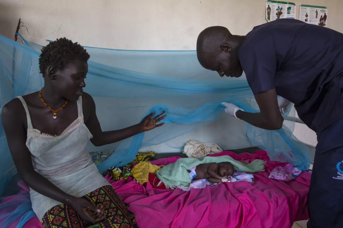 A healthcare worker checks on a baby in South Sudan