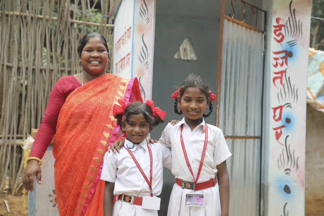 A woman stands next to her two daughters, India