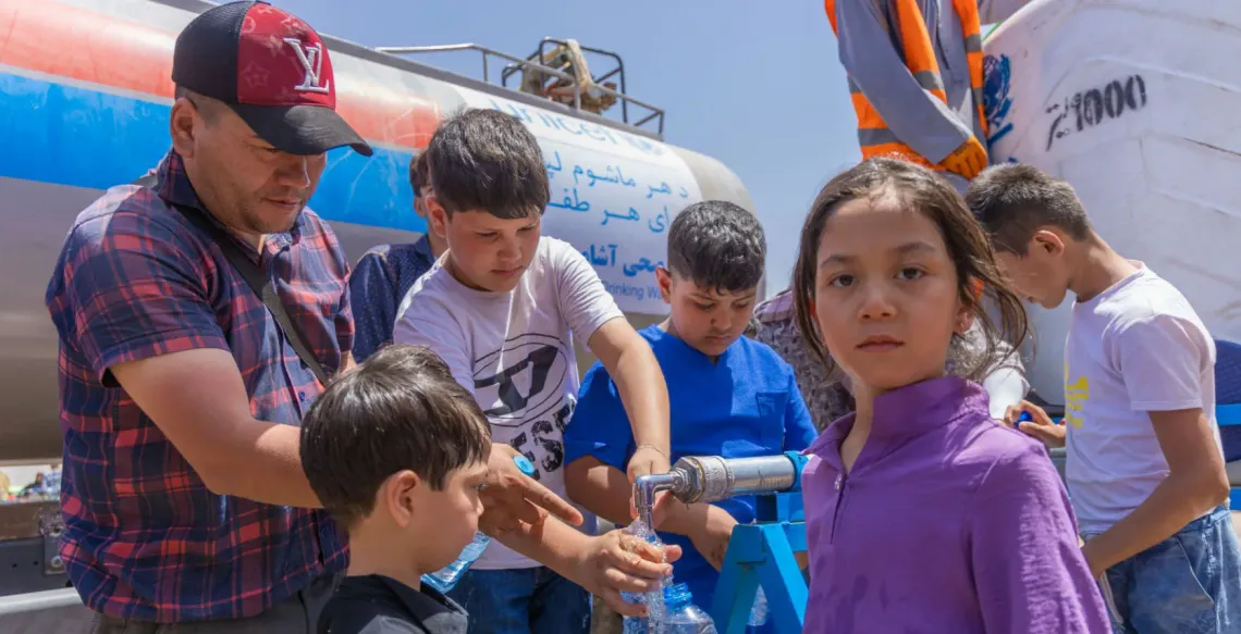 A group of people collecting water