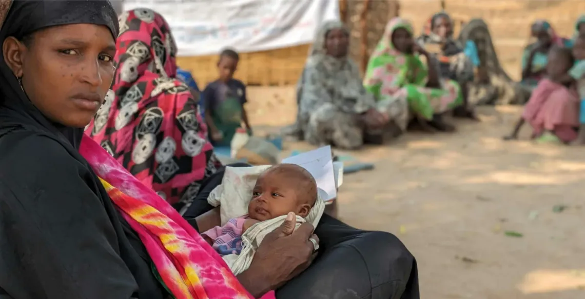 A mother holds a baby in her lap
