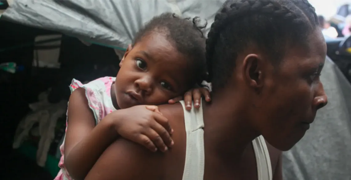 A woman carries a young girl on her back