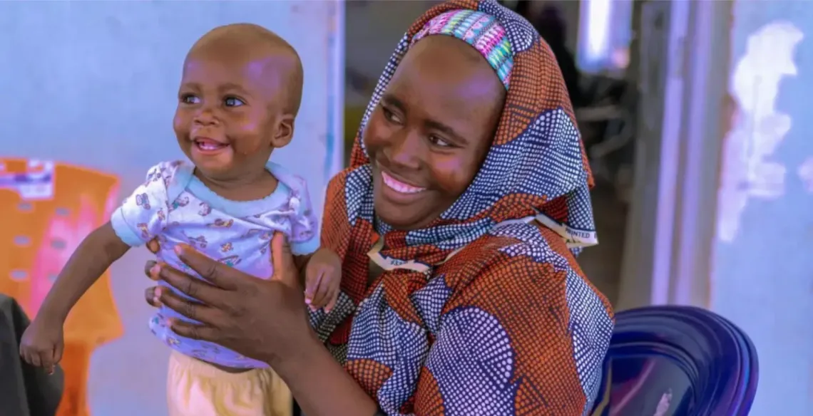 A woman holding a young children