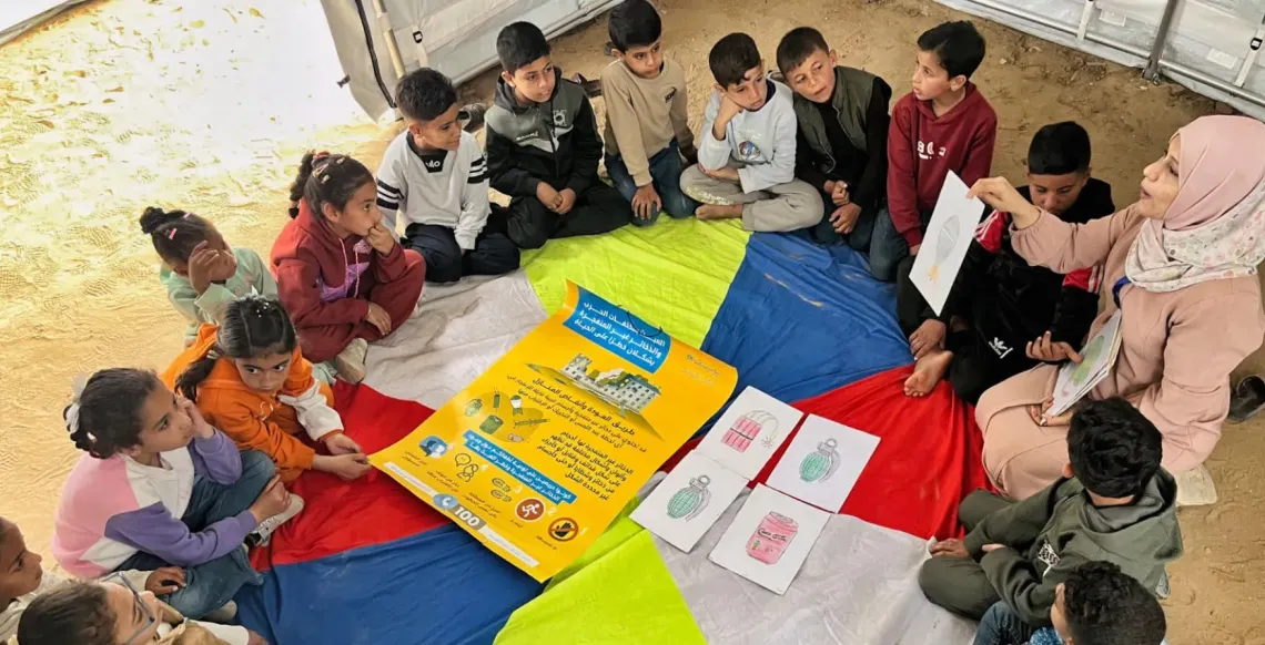 Children sit in a circle with a teacher