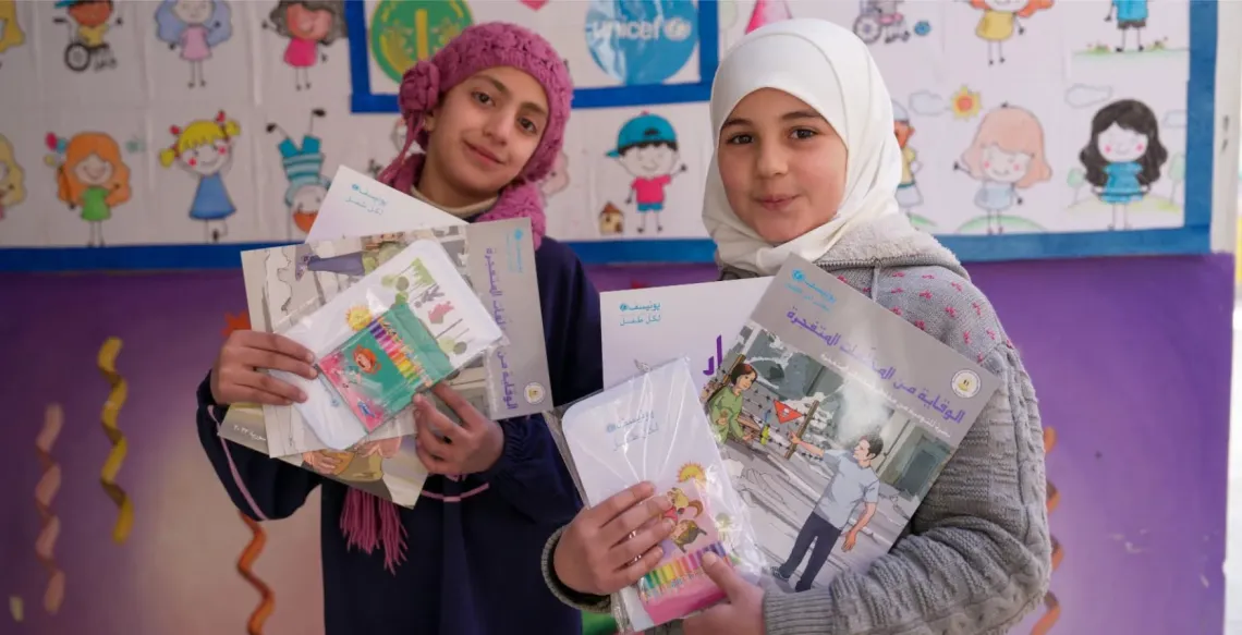 Two girls holding materials in their hands