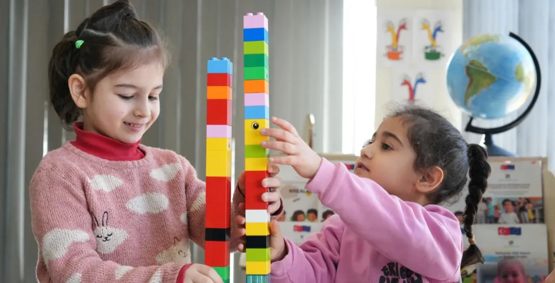 Two girls play with blocks