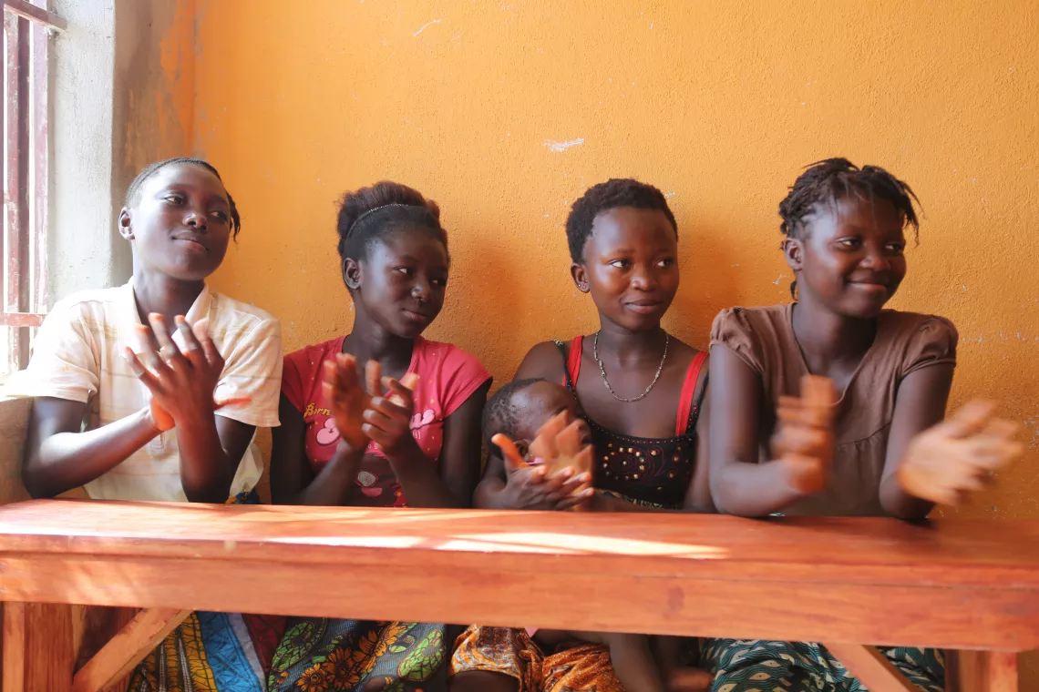 Four teenage girls sit at a desk, Sierra Leone