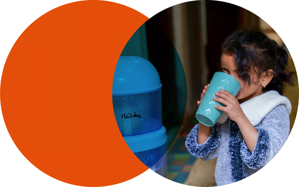 A 7-year-old girl drinks water from a dispenser at her home in Dhamar Governorate.