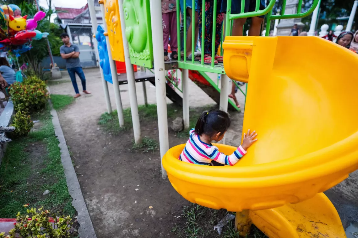 A child sliding down a slide in a public children's park 