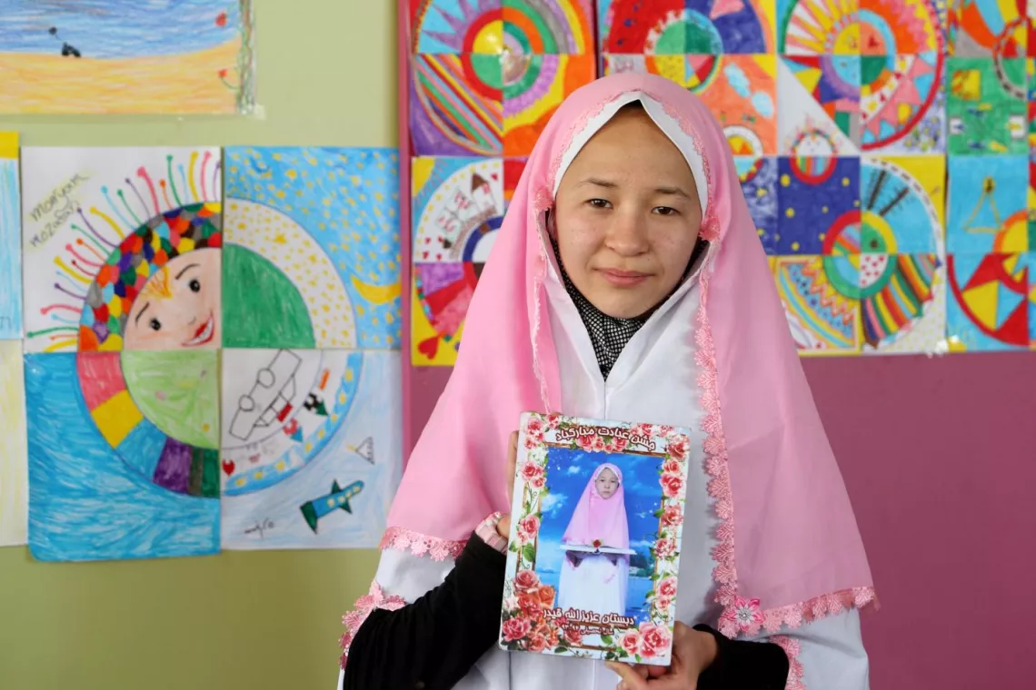 Serbia. Nilufar holds up a photo of herself.