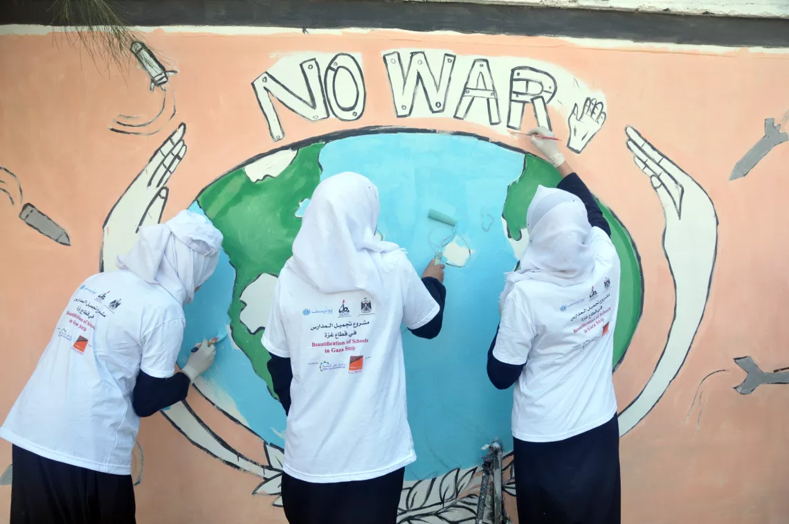 Children paint a mural on one of the schools in the Gaza Strip.