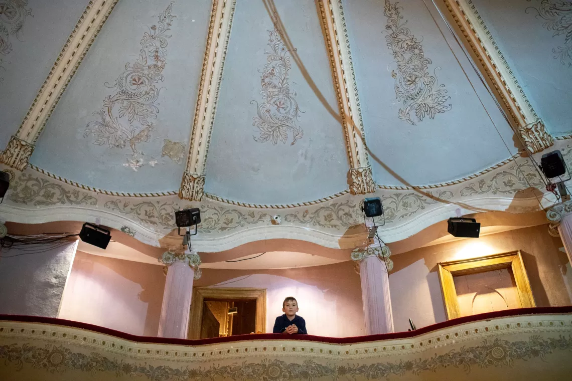 Ukraine. A boy looks over the balcony at a theatre.