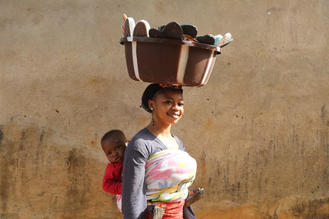 A mother and her child selling footwear.