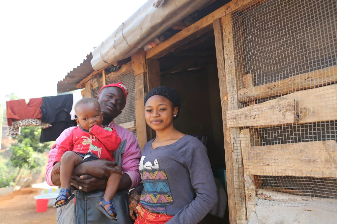 A couple and their son in front of their home.