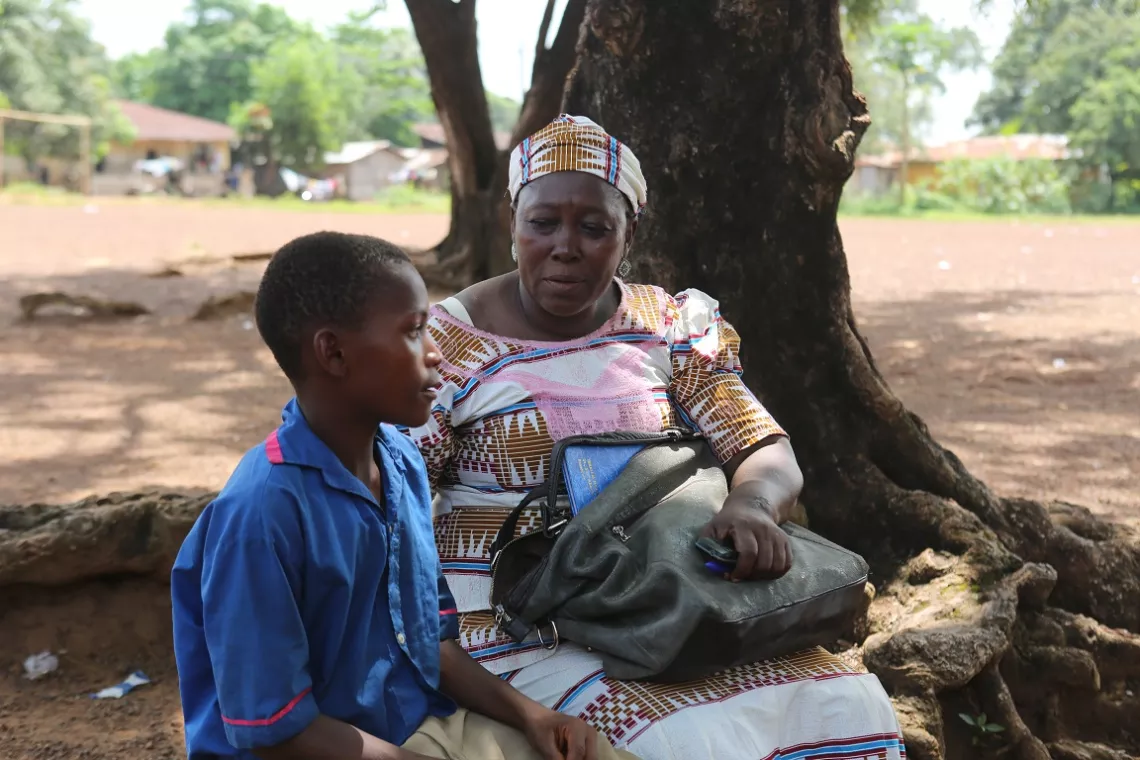 The chairperson of the Panlap Mothers&rsquo; Club visits Sullay Koroma at school.