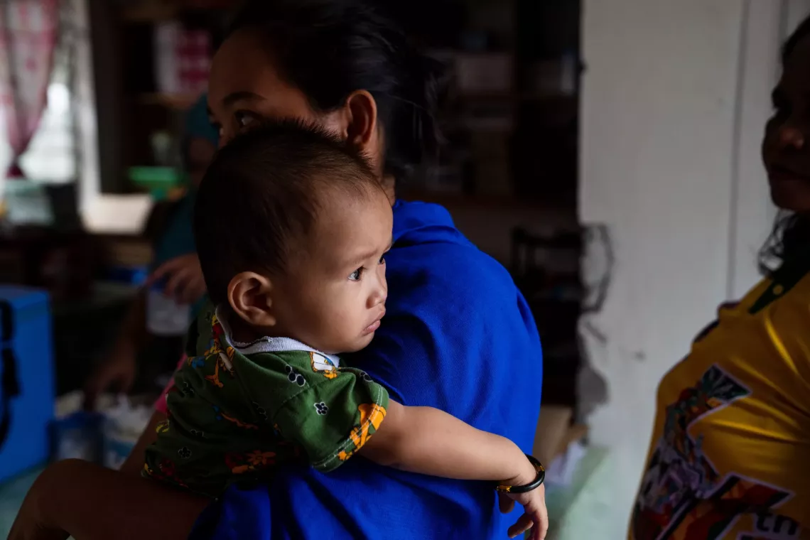 An infant child gazed outside from her mother's shoulder