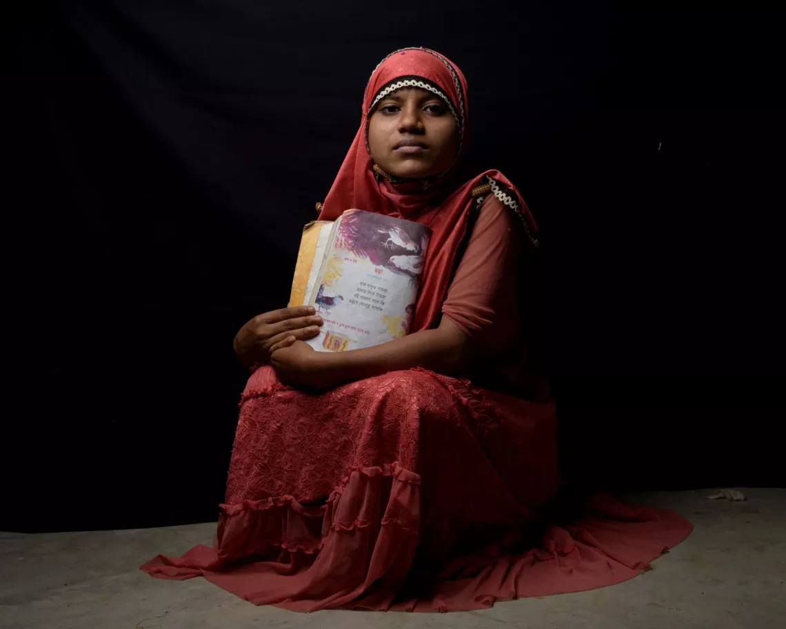 Bangladesh. A Rohingya refugee holds her favorite book of poetry 