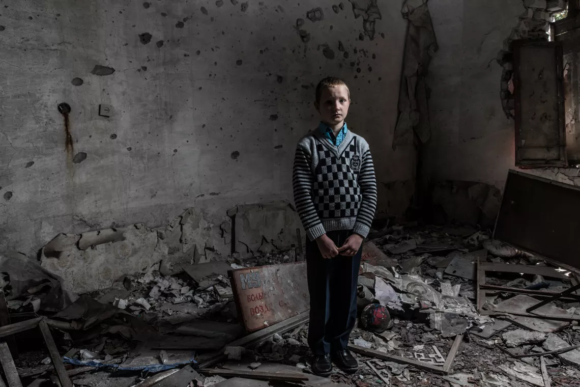 Yura Khromchenko, 9, stands in the classroom that took a direct hit from a shell