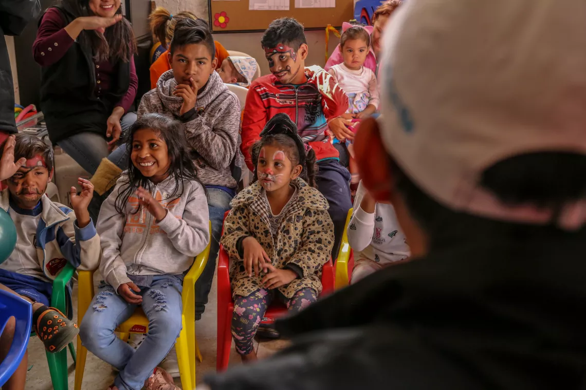 A UNICEF worker and children at a Child Friendly Space in Ecuador.