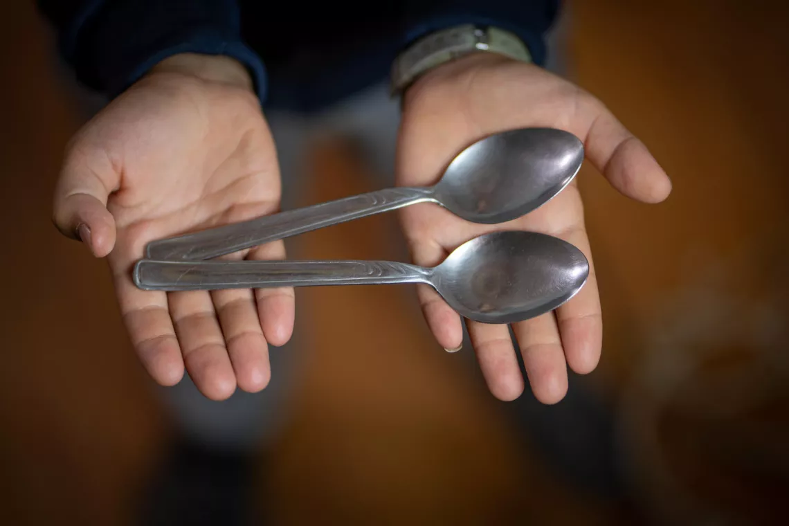 Jordan. Ayoub holds up a set of spoons in Za&rsquo;atari refugee camp.