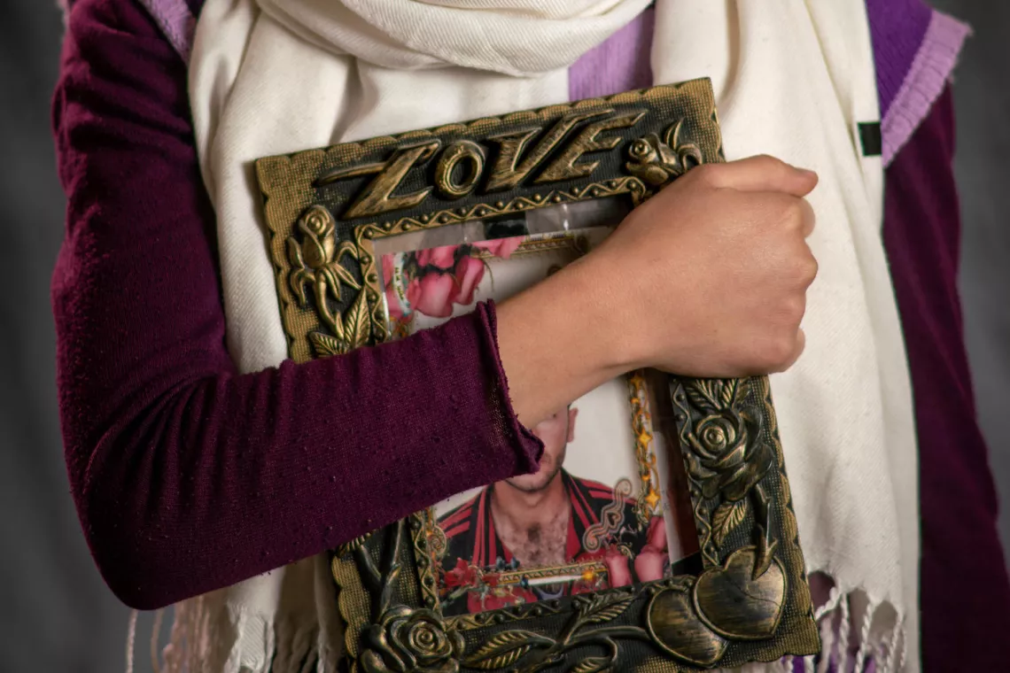 Jordan. Zaina, a refugee from Syria, holds a framed photograph of her father.