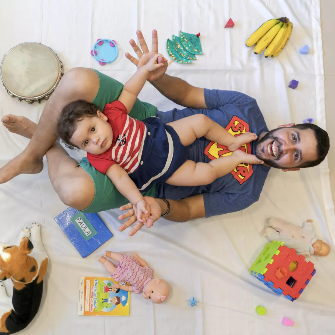 Baby Paula plays with her father Abdo.
