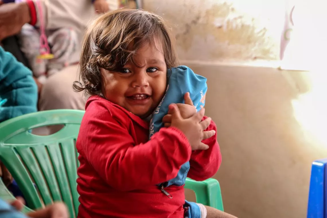 Una ni&ntilde;a abraza su camisa de UNICEF