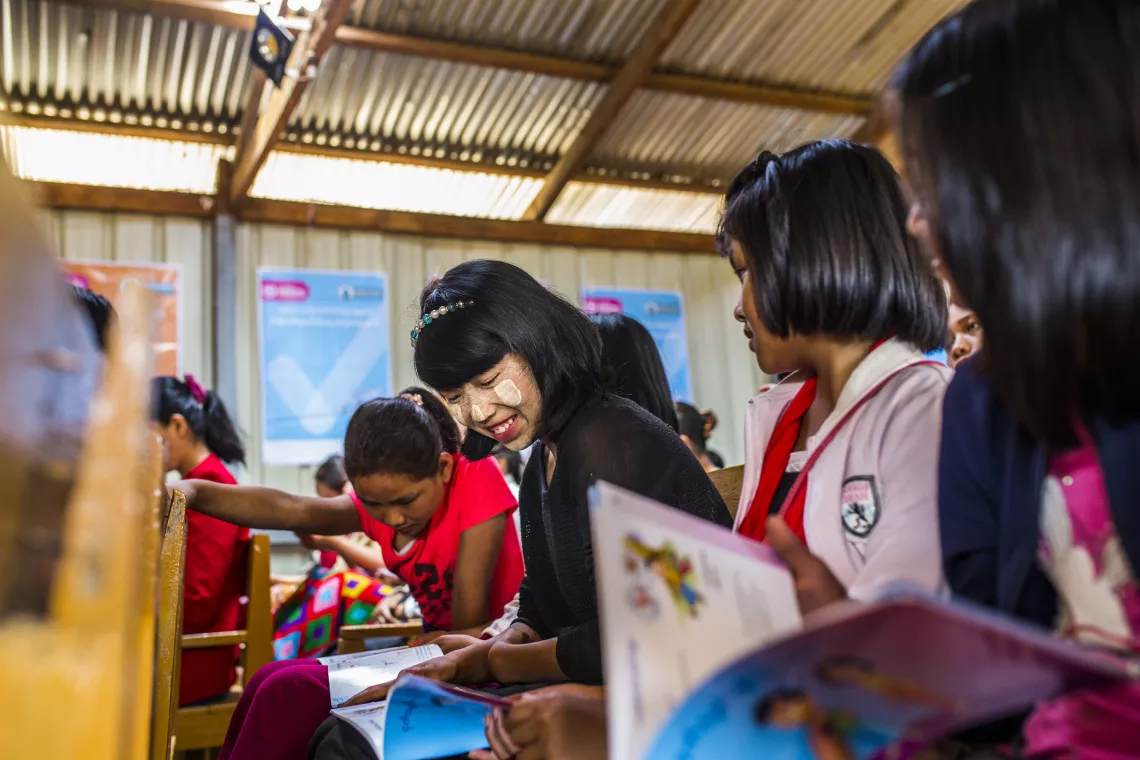 Adolescent girls look at booklets about menstrual health at the Menstrual Hygiene Day. 