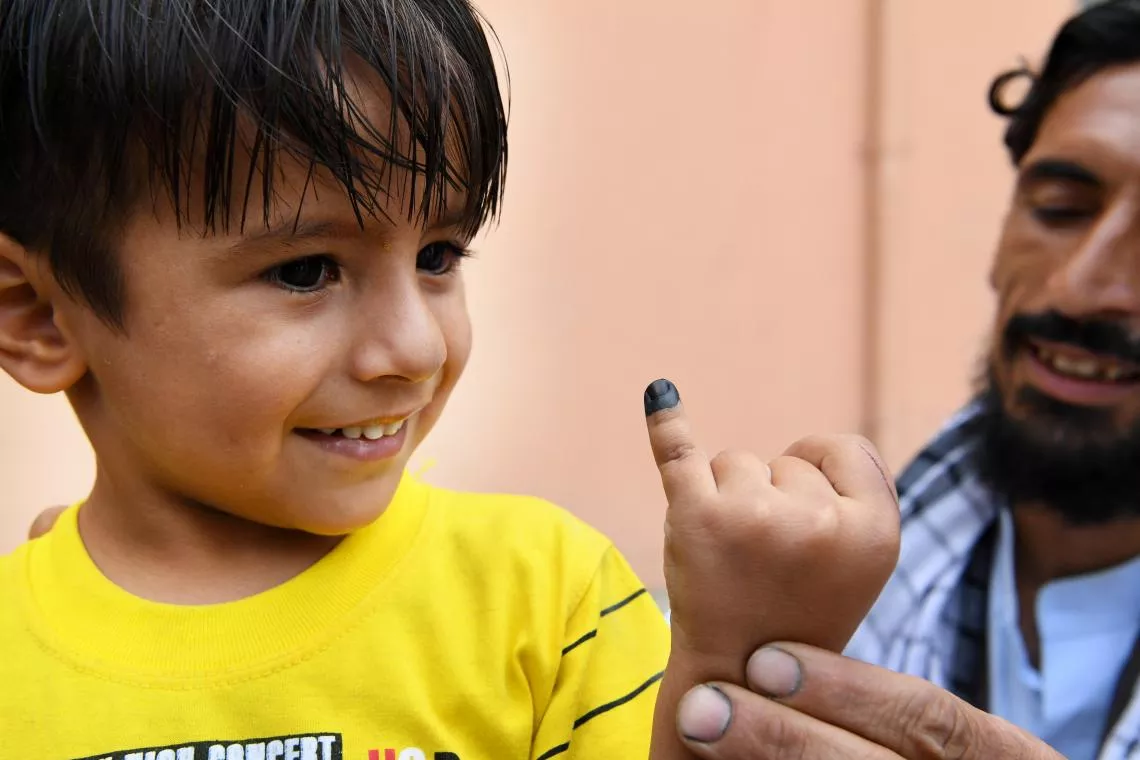 Un ni&ntilde;o muestra la marca que tiene en el dedo tras haber sido vacunado contra la poliomielitis. Los vacunadores de la poliomielitis fueron puerta por puerta en su vecindario de Kart-e-Naw, un suburbio de Kabul, Afganist&aacute;n.