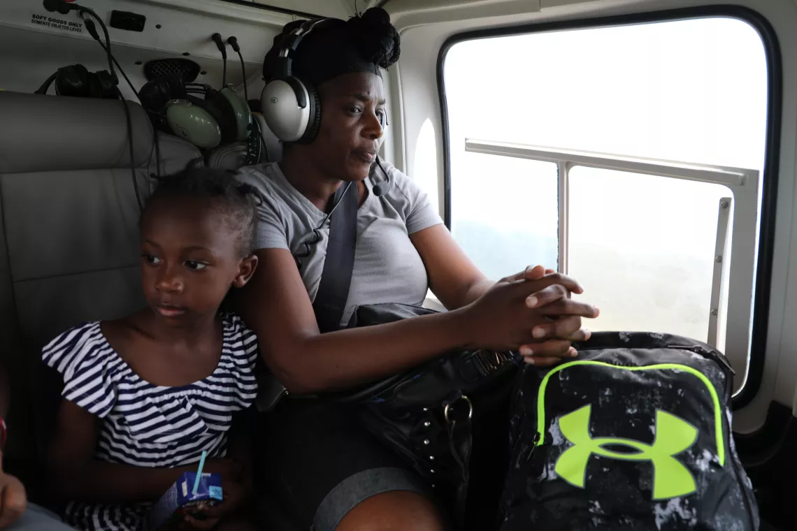 A woman and a child are evacuated after hurricane Dorian