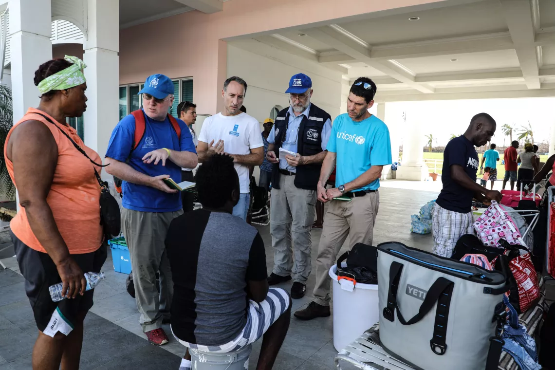 A UNICEF worker talks to families affected by the hurricane.